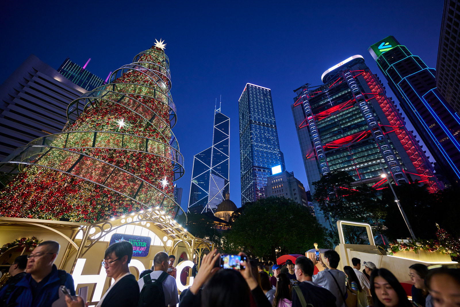 An illuminated Christmas tree beneath the Central skyline at Hong Kong WinterFest 2025